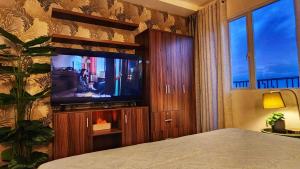 a bedroom with a flat screen tv and a bed at Bella Suite Bacolod in Bacolod