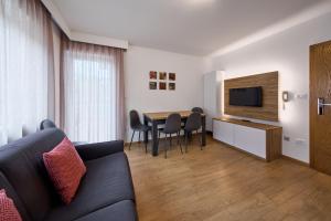 salon z kanapą i stołem z krzesłami w obiekcie Apartment Steinach w mieście Lagundo