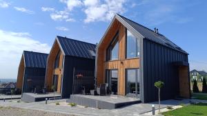 a modern house with a black roof at Domki Pod Łysicą- basen jacuzzi sauna in Krajno Pierwsze