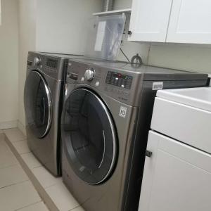 a washing machine and a dryer in a kitchen at Cozy room with private bathroom near subway in Toronto