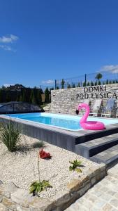 a swimming pool with a pink flamingo float in it at Domki Pod Łysicą- domki z basenem in Krajno Pierwsze