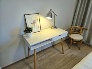 a desk with a plant and a lamp and a chair at Stylish top floor ap, with private parking, next to a tram stop in Tampere