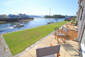 d'un balcon avec des chaises et une vue sur la rivière. dans l'établissement Harbour Escape, à Porthmadog