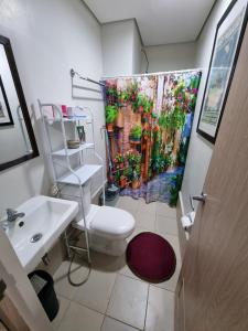 a bathroom with a toilet and a shower curtain at Condo for Rent Cheer Residences in Marilao +49 photos