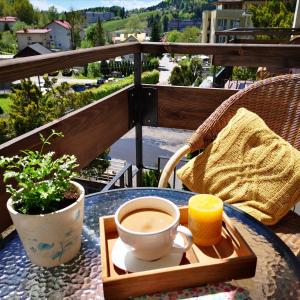 a cup of coffee sitting on a table on a balcony at Beskid Balans & SPA in Krynica Zdrój
