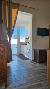a living room with a kitchen with a window and a table at Salento casavacanza Maria in Galatina