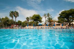 a large swimming pool with people on the beach at Glamping Costa Dorada in Vilanova i la Geltrú