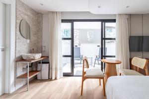 a bedroom with a bed and a table and chairs at Up Hotel Boutique in Bombinhas