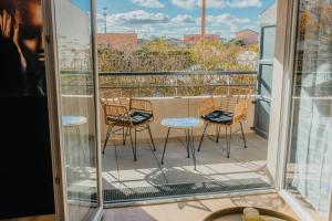 a balcony with three chairs and a table on a balcony at Love Room - Balnéo - Nuit Insolite - Intimité in Toulouse