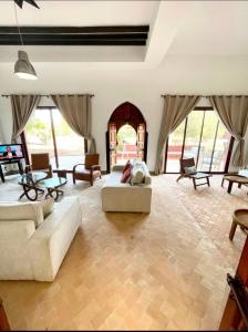 a large living room with couches and a dog laying on a couch at Riad du Bab atlas in Marrakesh