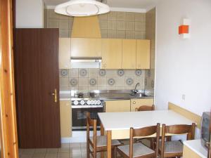 a kitchen with a table and chairs and a stove at Fenice in Bibione