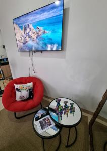 a living room with two tables and a red chair at Condo for Rent Cheer Residences in Marilao