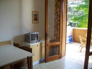 a room with a door open to a patio with a television at Fenice in Bibione