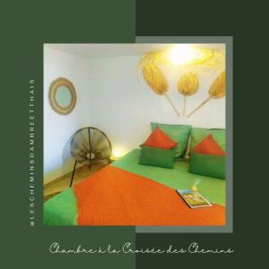 a bedroom with a bed with green and orange pillows at Les Chemins d'Ambre et Thaïs in La Regrippière