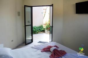 a bedroom with a bed with a sliding glass door at Pousada D'Ibiza - Itanhaém in Itanhaém