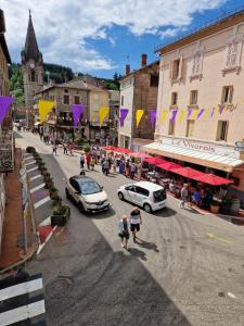 a city street with cars and people walking on the street at logodrine2 in Lalouvesc +2 photos