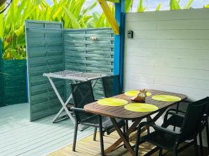a wooden table and chairs on a patio at Bungalow Atoll Sainte-Anne in Sainte-Anne