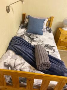 a bed with a blue blanket on top of it at Henties Central Stay in Hentiesbaai