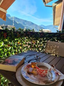 a book and a cup of coffee on a table at Casa Alce in Chiavenna