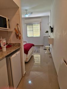 a small room with a bed and a kitchen at Flat Cavalinho Branco apt 610 in Águas de Lindóia