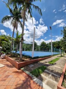 a swimming pool with palm trees in a park at Flat Cavalinho Branco apt 610 in Águas de Lindóia