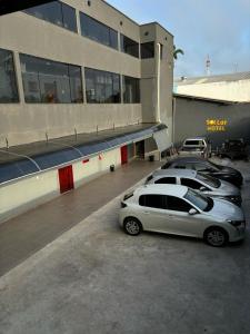 een groep auto's geparkeerd voor een gebouw bij Sol lar hotel flats in Paragominas
