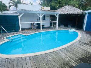 a swimming pool on a wooden deck with a house at Bungalow Atoll Sainte-Anne in Sainte-Anne