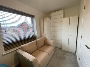 a living room with a couch and a large window at Cozy double room in Wavendon