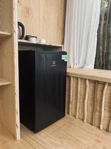 a black refrigerator in a room with a window at Floating market cabin in Can Tho +34 photos