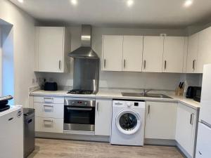 a kitchen with a washing machine and a stove at Cozy double room in Wavendon