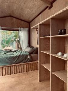 a bedroom with a bed and shelves in a room at Floating market cabin in Can Tho