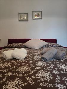 a bed with three pillows on top of it at Casa rosa in Palau