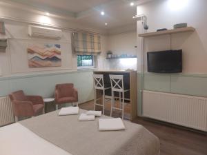 a room with a table and two chairs and a television at Bellmatini in Belgrade