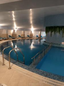 a large swimming pool with blue water in a building at Condor Resort in Dulceşti