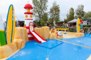 einen Wasserpark mit einem Spielplatz mit einem Leuchtturm und einem Surfbrett in der Unterkunft Vlugtenburg in s-Gravenzande
