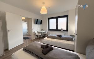 a bedroom with two beds and a table in it at BEGE APARTMENTS ConnectPoint in Nettetal +11 photos
