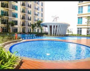 a large swimming pool in front of a building at Apt Puri Orchard Lani's Transit in Jakarta