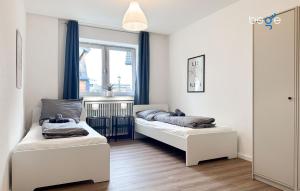 two beds in a room with a window at BEGE APARTMENTS ConnectPoint in Nettetal