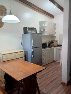 a kitchen with a wooden table and a refrigerator at Parcela de Agrados in Molco