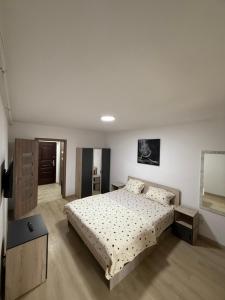 皮特什蒂Nicolle Studio 3的一间带床和桌子的白色卧室