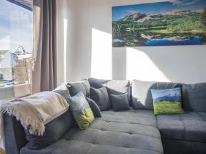 a grey couch with pillows in a living room at Welcome in - Apartment 59-G 'Leni' direkt an der Piste, mit Balkon, Sauna und Schwimmbad in Winterberg