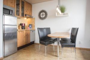 a kitchen with a table and chairs and a refrigerator at Welcome in - Apartment 59-G 'Leni' direkt an der Piste, mit Balkon, Sauna und Schwimmbad in Winterberg