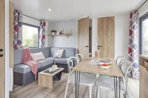 a living room with a couch and a table at Camping familial 3 Etoiles avec piscine Carrefour de l'Ardèche in Saint-Remèze