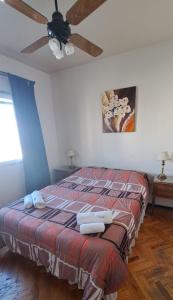 Un dormitorio con una cama con ventilador de techo. en Colon Apartment, en Mendoza