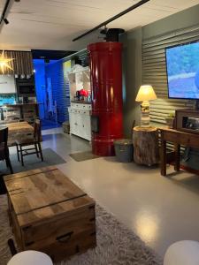 a living room with a red water tank and a table at Vanha Ravintola Ölvin Suolatorilla - Vanhan Kanttorilan yhteydessä in Lovisa
