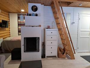 a living room with a fireplace and a bed at Lomaloukas 1 in Syöte