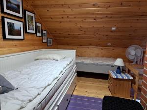 a bedroom with a bed in a wooden room at Lomaloukas 1 in Syöte