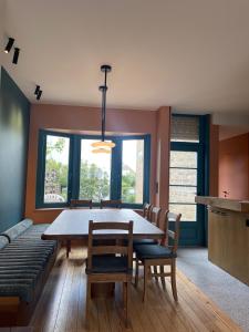 a dining room with a table and chairs and a couch at -Le bel abri- à 2 pas de la mer in De Panne