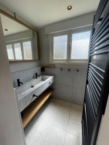 a bathroom with a sink and a mirror at -Le bel abri- à 2 pas de la mer in De Panne