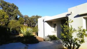 une maison blanche avec des arbres en arrière-plan dans l'établissement Villa Stella Diana, 12 pers, 100 m plage, à Pinarellu